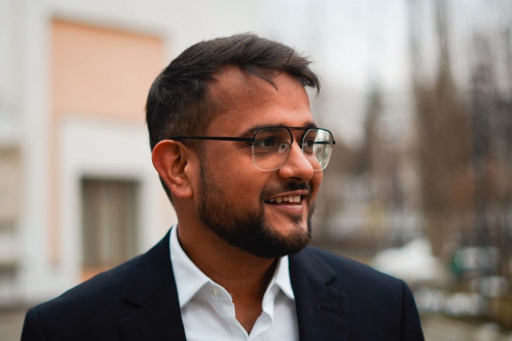 Professional portrait of a smiling businessman in a blazer outdoors.